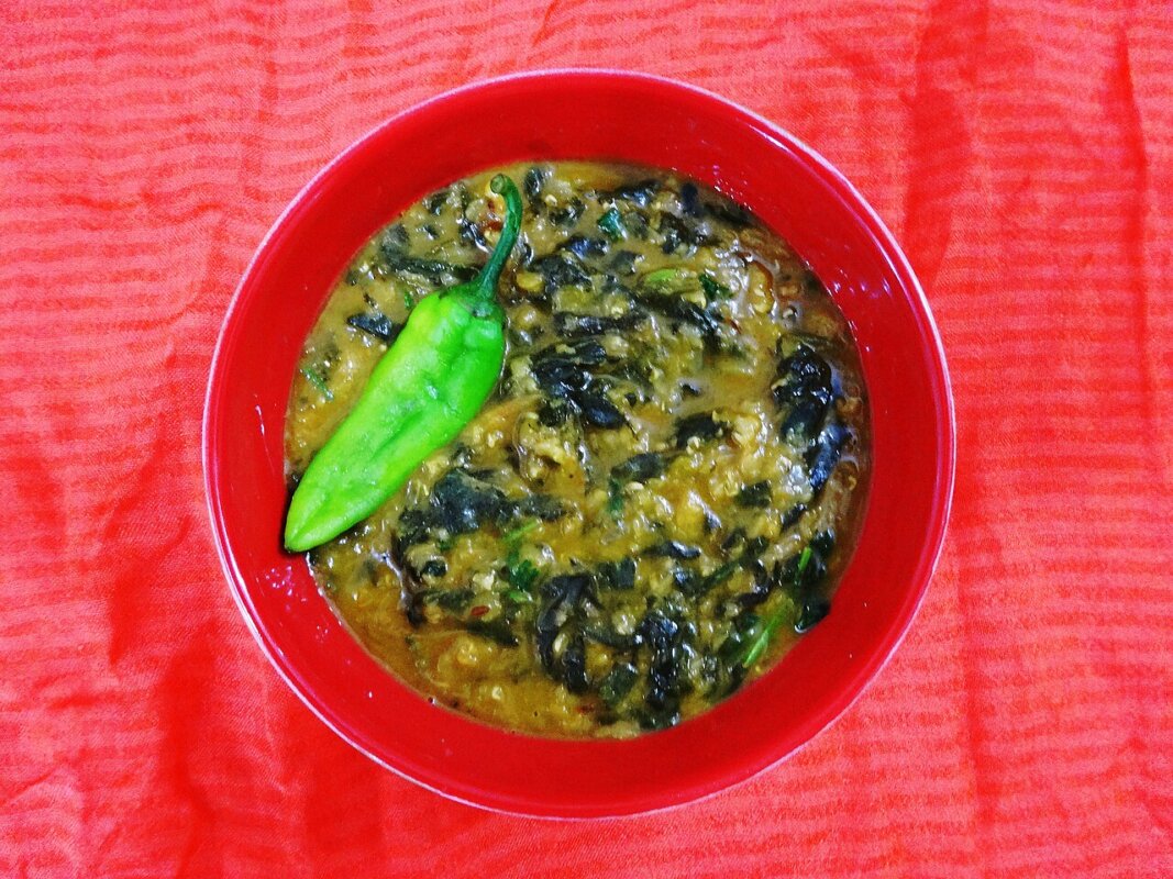Dahl de lentilles corail aux épinards, servi avec sa garniture.